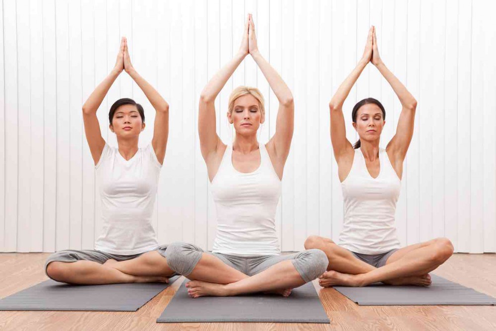 three women practising Kundalini yoga