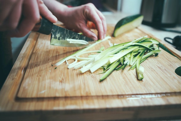 person slicing zucchini